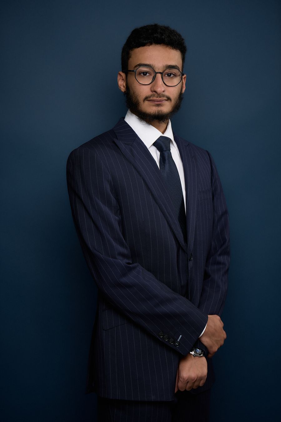 Portrait of Aziz AlShammari in a navy pinstripe suit